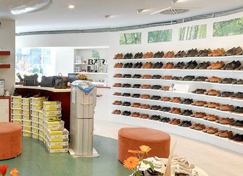 Schuhgeschäft mit großer Auswahl an Herrenschuhen Innenansicht eines Schuhgeschäfts mit Regalen voller Herrenschuhe und einer gemütlichen Sitzecke