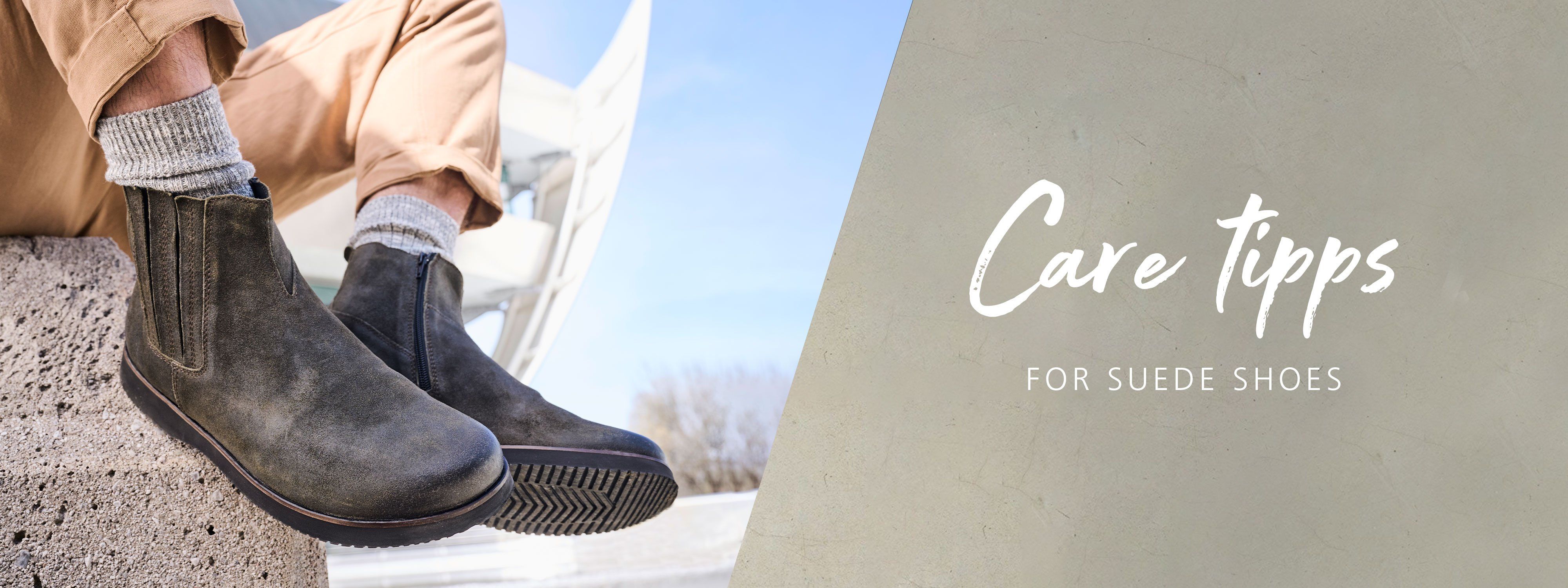 Suede Shoe Care Tips - Stylish and Durable Footwear A person wearing stylish suede boots with rolled-up beige pants, sitting on a stone ledge with a modern architectural background, featuring care tips for suede shoes.