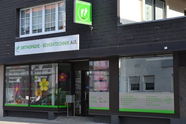 Orthopädieschuhtechnik Aul Ladenfront Außenansicht des Geschäfts Orthopädieschuhtechnik Aul mit Schaufenstern und grünem Firmenschild