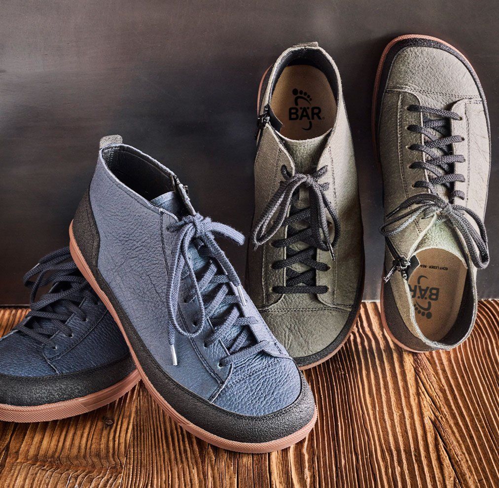 Stylish high-top sneakers in grey and blue A pair of high-top sneakers in grey and blue color with black laces on a wooden floor