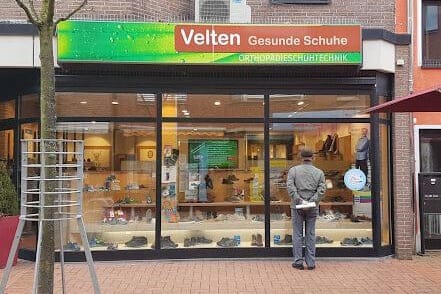Schaufenster von Velten Gesunde Schuhe in einer Einkaufsstraße Ein Mann steht vor dem Schaufenster von Velten Gesunde Schuhe, einem Geschäft für orthopädische Schuhtechnik.