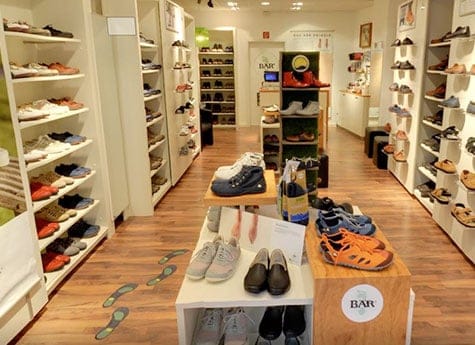 Vielfältiges Schuhangebot in modernem Schuhladen Innenansicht eines Schuhladen mit verschiedenen Schuhmodellen auf Regalen und Tischen