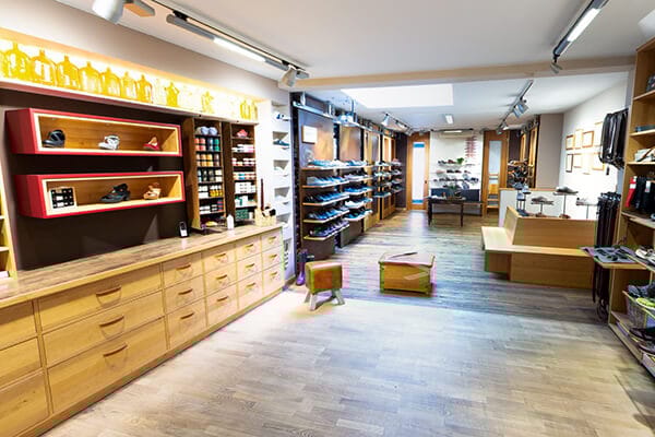 Moderner Schuhladen mit großen Holzregalen und umfangreichem Schuhsortiment Innenansicht eines modernen Schuhgeschäfts mit hellen Holzregalen und einer Vielzahl von Schuhen.