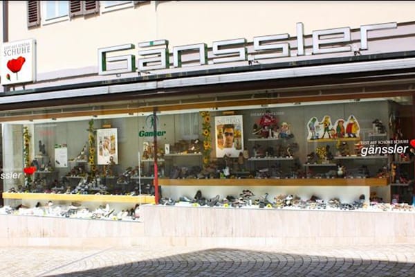 Frontansicht des Gänssler Schuhgeschäfts mit gläsernem Schaufenster und verschiedenen Modellen von Schuhen präsentiert
