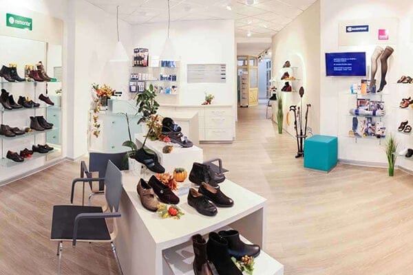 Moderne Schuhboutique mit stilvollem Interieur und vielfältiger Auswahl Innenansicht einer modernen Schuhboutique mit verschiedenen Schuhen auf Regalen und Tischen