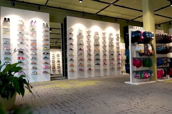 Moderne Schuhgeschäft-Innenansicht mit verschiedenen Sneaker-Modellen Innenansicht eines modernen Schuhgeschäfts mit Regalreihen voller verschiedener Sneaker-Modelle, farbenfrohe Auswahl an Wanddisplays.