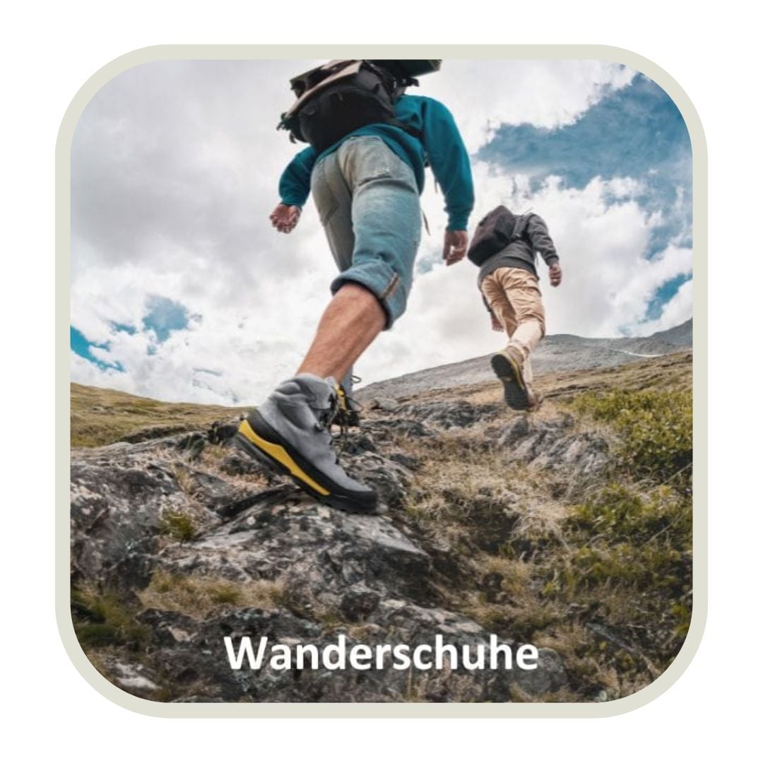 Zwei Wanderer mit robusten Wanderschuhen erklimmen einen steinigen Pfad in malerischer Berglandschaft.