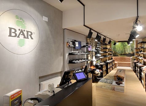 Innenansicht eines modernen Schuhgeschäfts mit gemütlicher Atmosphäre Ein heller und modern gestalteter Schuhladen mit Regalen voller Schuhe und einem eleganten Empfangstresen.