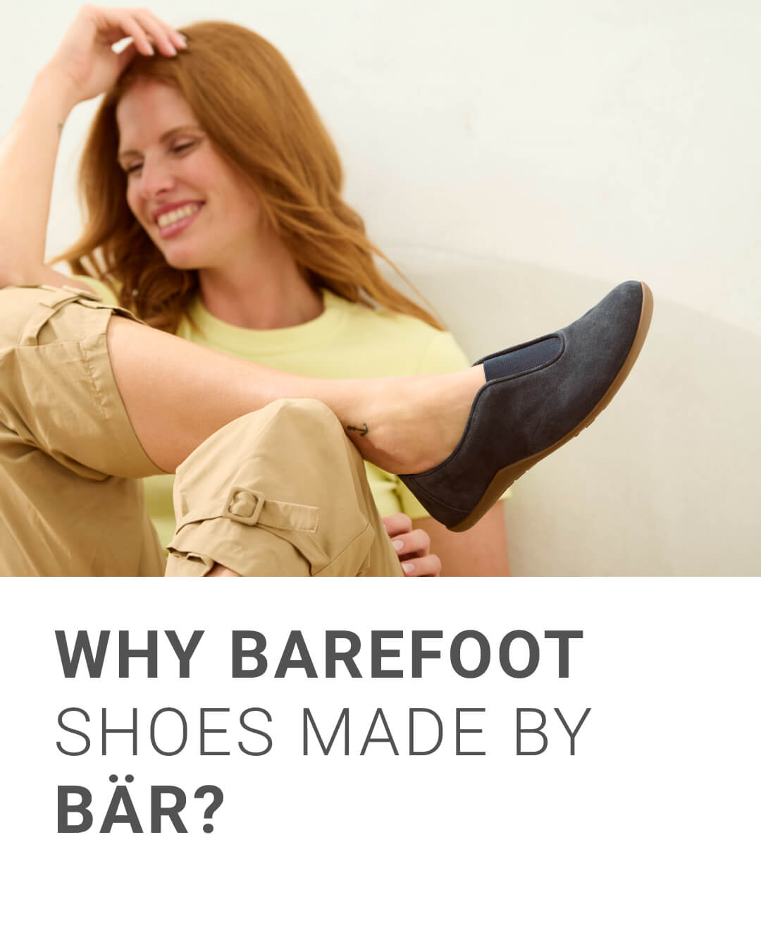 Woman Relaxing in Comfort with BÄR Barefoot Shoes Smiling woman wearing comfortable BÄR barefoot shoes while sitting casually indoors.
