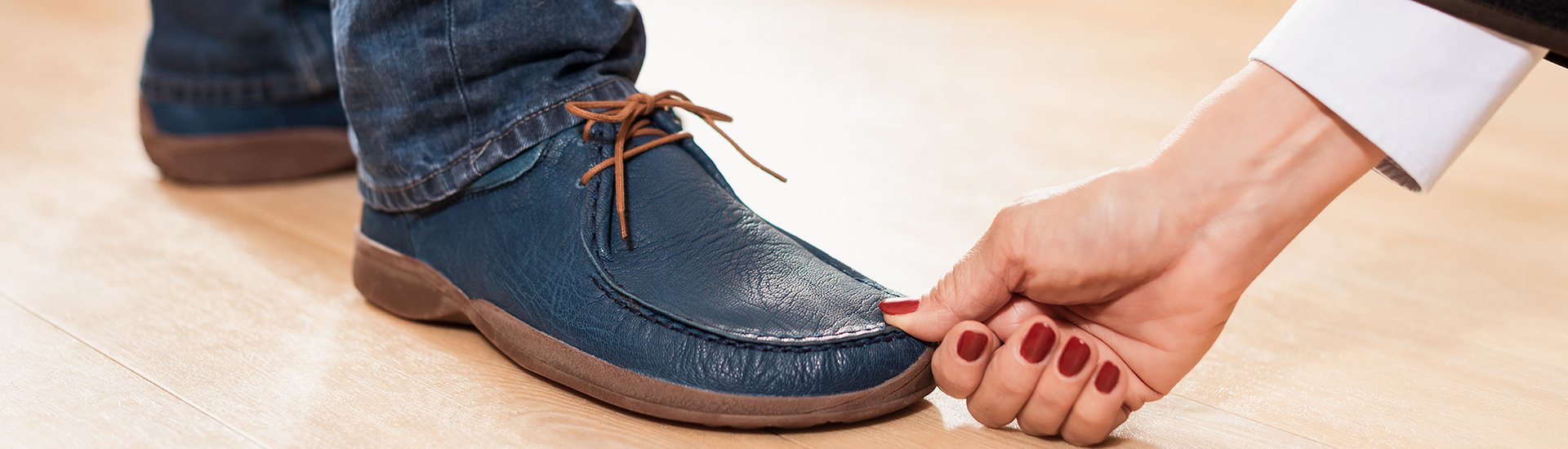 Bequeme blaue Lederschuhe mit Schnürung Person prüft bequeme blaue Lederschuhe mit Schnürung auf Holzfußboden