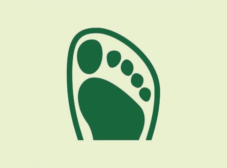 Grünes Fußabdruck-Symbol auf beigem Hintergrund, das Nachhaltigkeit darstellt
