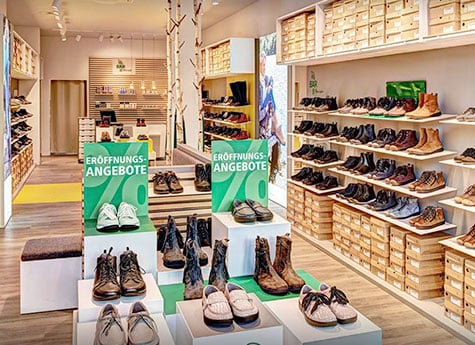 Moderner Schuhladen mit Eröffnungsangeboten Schuhgeschäft mit Regalen voller Schuhe und Hinweisen auf Eröffnungsangebote