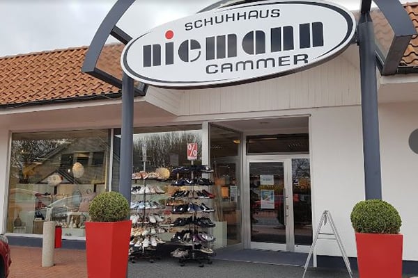 Das Schuhhaus Niemann in Cammer mit ausgestellten Schuhen vor dem Eingang und einem markanten Logo auf dem Schild.