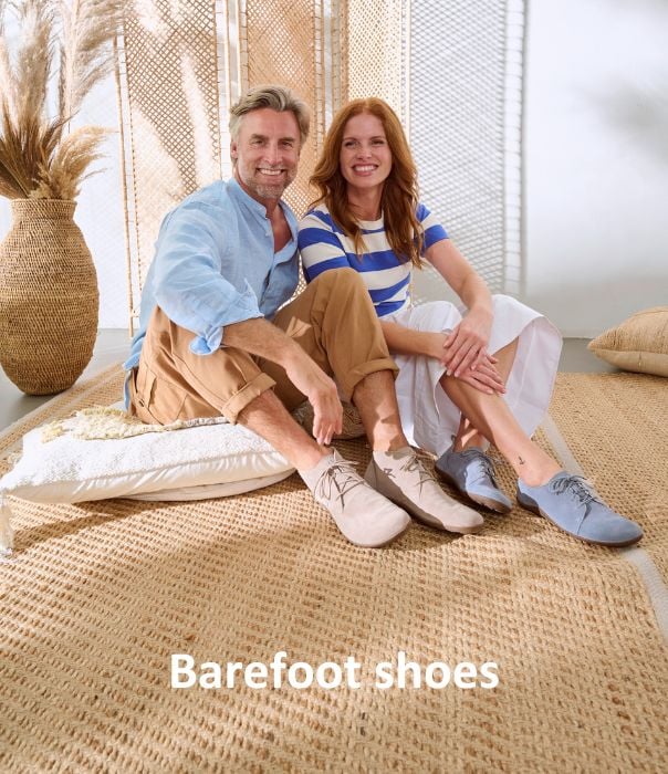 Comfortable barefoot shoes for a natural walking experience A smiling couple sitting on woven mats, wearing comfortable barefoot shoes