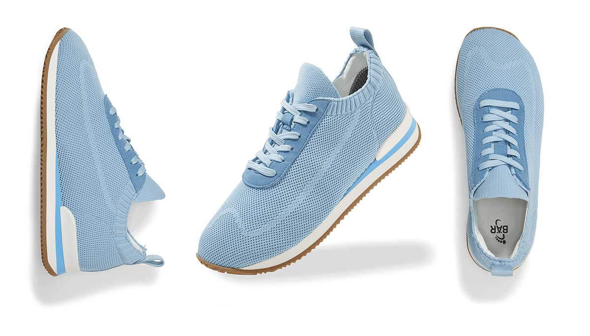 Three light blue athletic sneakers viewed from multiple angles on a white background, showcasing their design.
