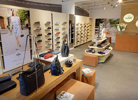 Moderner Schuh- und Taschenshop mit vielfältiger Auswahl Innenansicht eines stilvollen Schuh- und Taschengeschäfts mit moderner Einrichtung und großer Produktauswahl