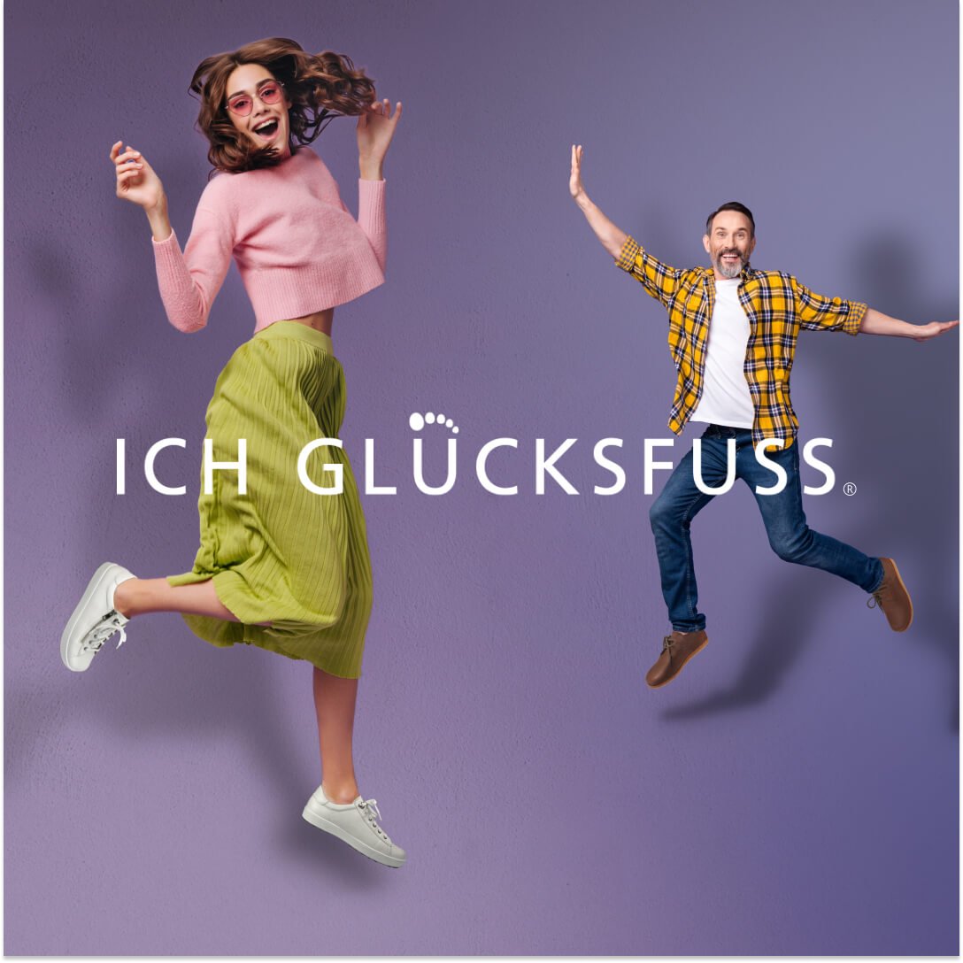 A woman and a man are joyfully jumping against a purple background, wearing casual, colorful outfits, representing the Ich Glücksfuss brand.