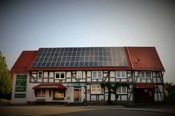 Fachwerkhaus mit modernen Solarmodulen auf dem Dach, das Tradition und moderne Technologie verbindet