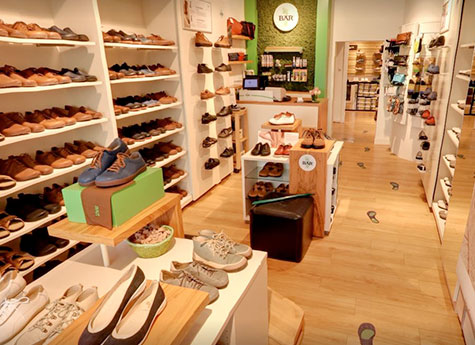 Moderner Schuhladen mit einer vielfältigen Auswahl an Schuhen für Damen und Herren Innenansicht eines Schuhladens mit zahlreichen Regalen voller Schuhe für Damen und Herren, gemütliche Atmosphäre mit Holzboden und dekorativen Elementen