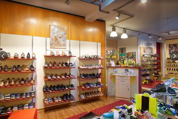 Innenraum eines Schuhgeschäfts mit Regalen voller verschiedener Schuharten