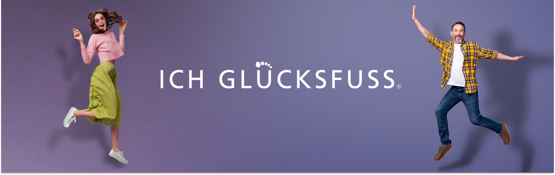 A woman and man joyfully jumping beside the 'Ich Glücksfuss' logo on a purple wall