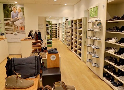 Moderner Schuhgeschäft-Innenraum mit vielfältiger Auswahl Innenansicht eines modernen Schuhgeschäfts mit Regalen voller Schuhe und einer gemütlichen Atmosphäre