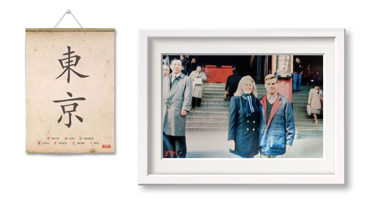 A framed photograph depicting a group of people standing on steps, alongside a vintage-style poster featuring Japanese kanji characters.