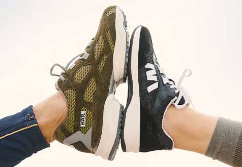 Zwei Paar Sneakers im Vergleich: Stylische Sportschuhe für Alltag und Freizeit Zwei Personen tragen unterschiedliche Sneakers, eine in olivgrün und die andere in schwarz, die zueinander zeigen.