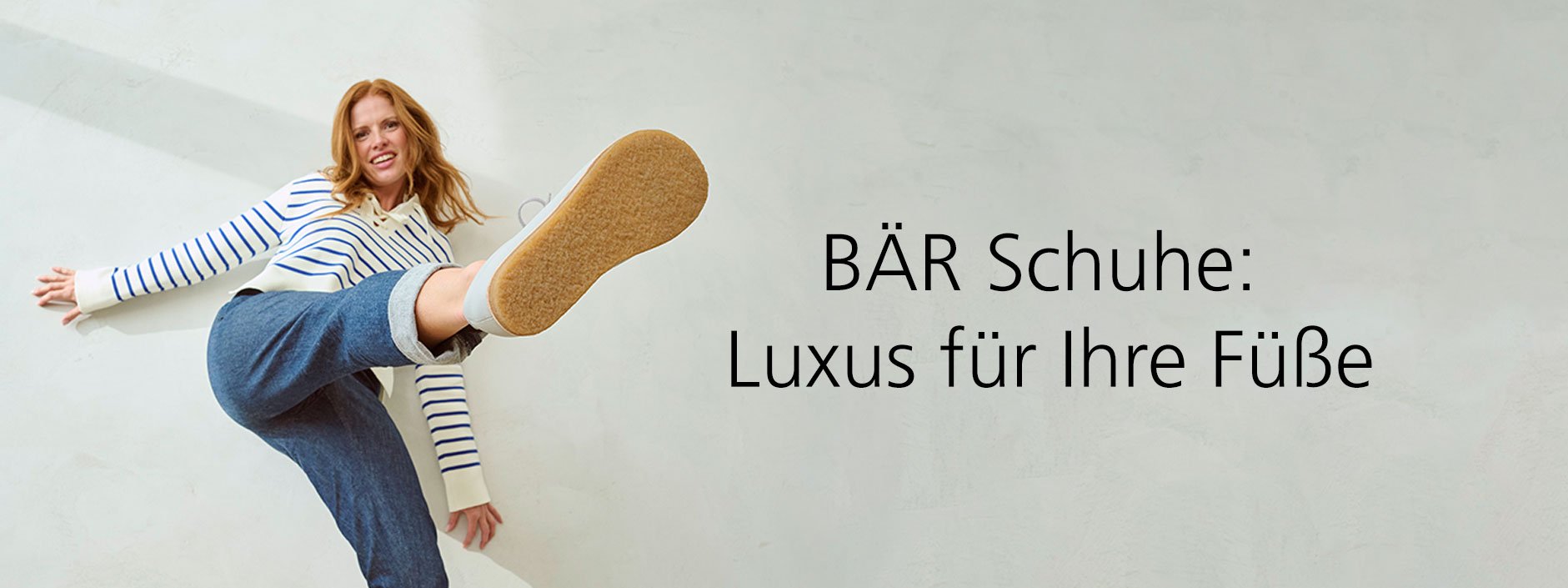 Bequeme Schuhe von BÄR für besten Tragekomfort Eine Frau in lässiger Kleidung präsentiert ein Paar bequemer BÄR Schuhe mit großer Begeisterung.