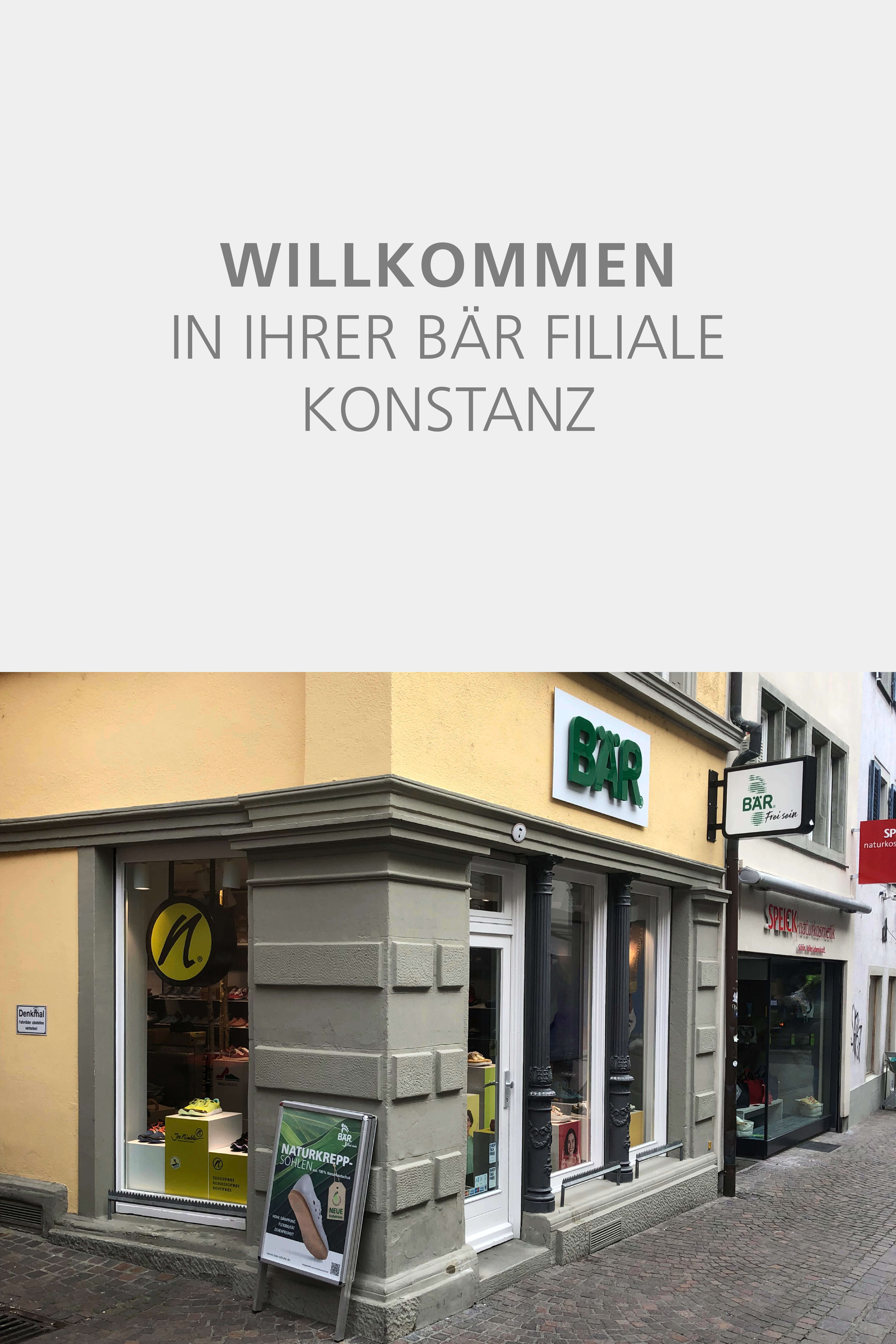 Entrance of the BÄR shoe store in Konstanz with signs and storefront display
