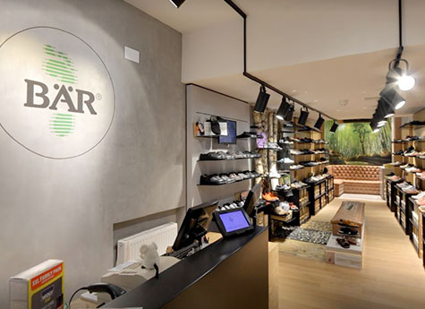 Innenansicht eines modernen Schuhgeschäfts mit gemütlicher Atmosphäre Ein heller und modern gestalteter Schuhladen mit Regalen voller Schuhe und einem eleganten Empfangstresen.