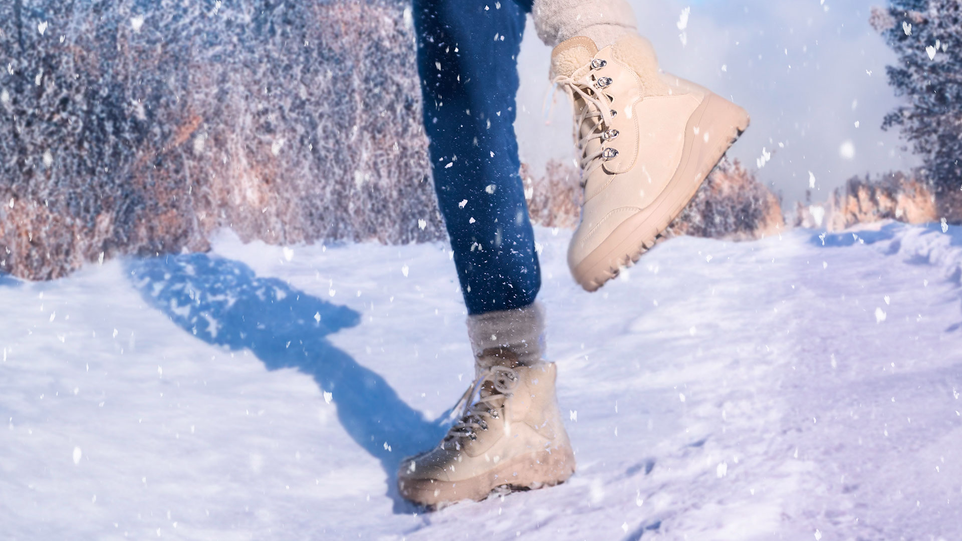 Wasserdichte Winterstiefel für Damen im Schnee Nahaufnahme von beige Winterstiefeln, die durch eine verschneite Landschaft gehen
