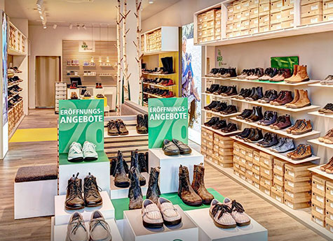 Moderner Schuhladen mit Eröffnungsangeboten Schuhgeschäft mit Regalen voller Schuhe und Hinweisen auf Eröffnungsangebote