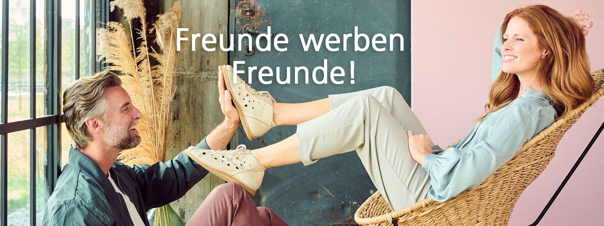 Freunde werben Freunde - Marketingkampagne Mann und Frau machen High-Five mit den Füßen, Text 'Freunde werben Freunde'