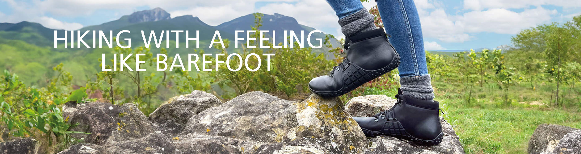 Hiking Boots Offering a Barefoot Experience Person wearing hiking boots standing on rocky terrain with mountains in the background
