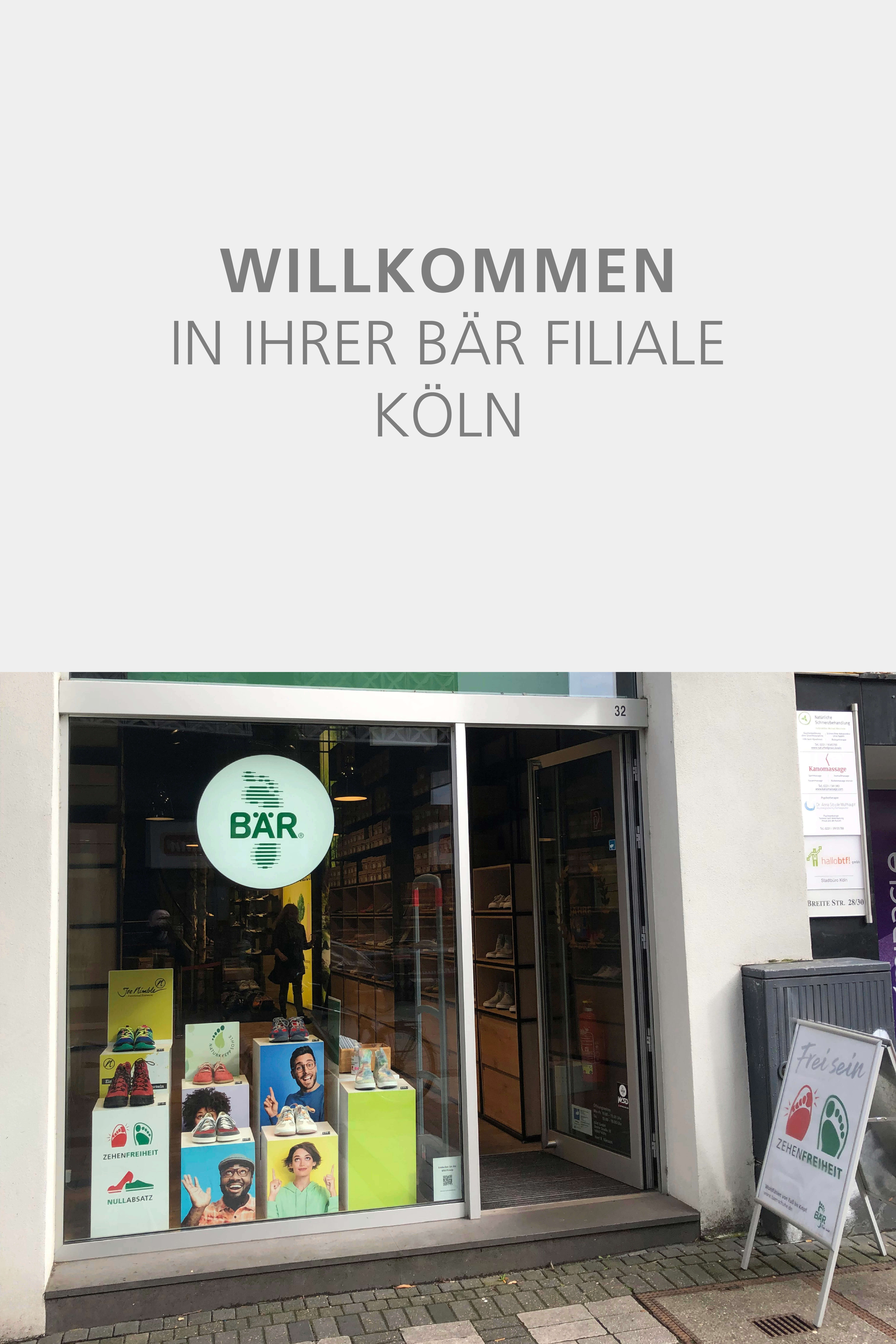 Storefront of BÄR Shoes in Cologne featuring shoe displays and promotional posters.
