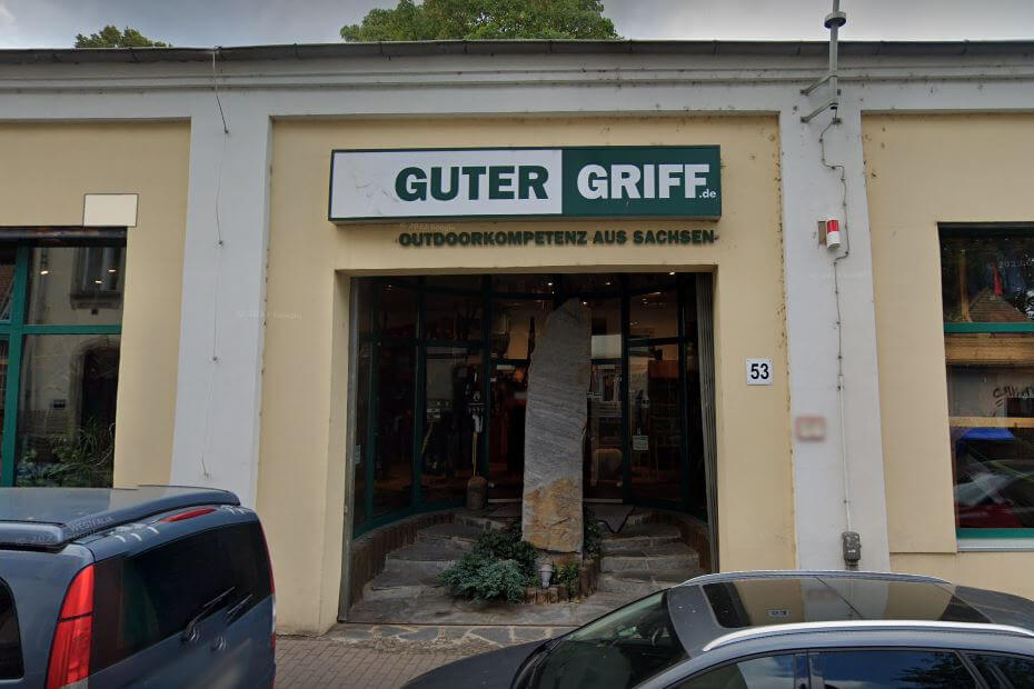 Eingangsbereich des Outdoor-Ladens 'Guter Griff' in Sachsen Foto des Eingangs vom Outdoor-Fachgeschäft 'Guter Griff' in Sachsen mit Schildern und Autos davor.