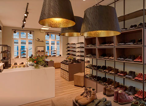 Cozy Shoe Store Interior with Modern Lighting Interior view of a stylish shoe store with modern lighting, featuring a variety of shoes displayed on shelves and a welcoming atmosphere.