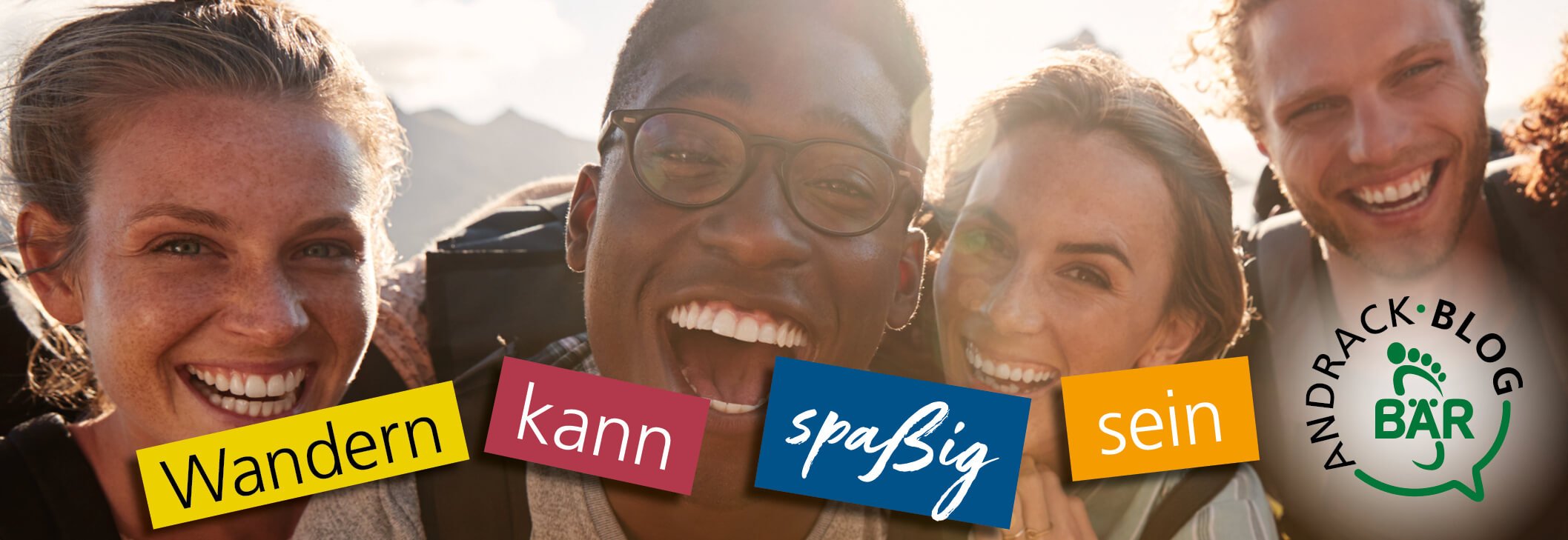 Hiking Can Be Fun - Andrack Blog Bär Four smiling friends enjoying a hiking trip with mountains in the background, promoting the Andrack Blog Bär and the idea that hiking can be fun.