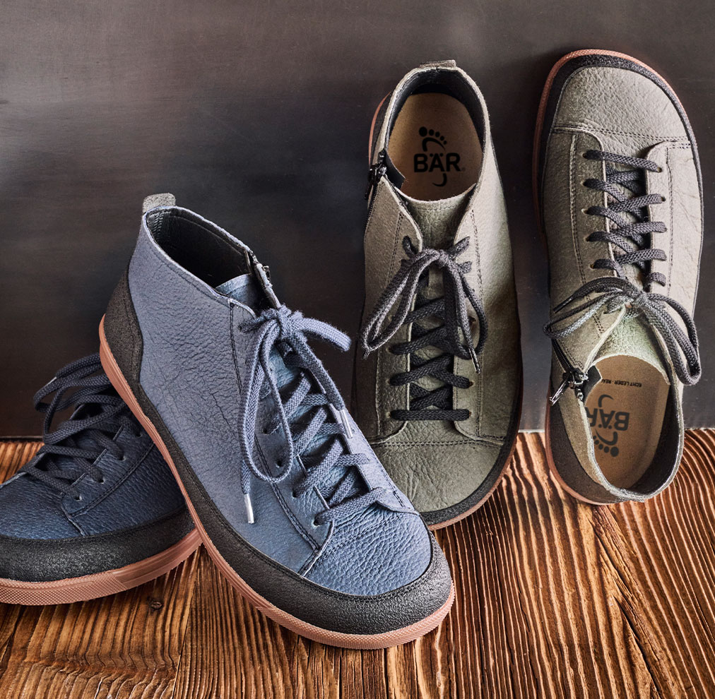 Stylish high-top sneakers in grey and blue A pair of high-top sneakers in grey and blue color with black laces on a wooden floor