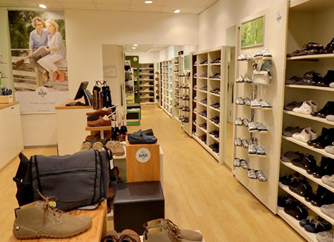 Moderner Schuhgeschäft-Innenraum mit vielfältiger Auswahl Innenansicht eines modernen Schuhgeschäfts mit Regalen voller Schuhe und einer gemütlichen Atmosphäre