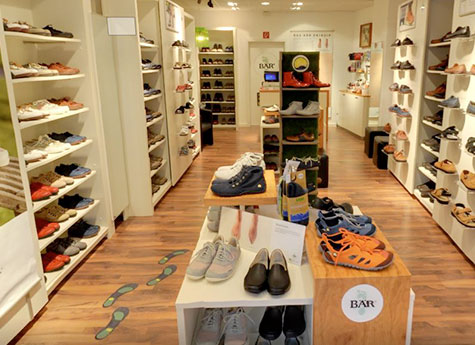 Vielfältiges Schuhangebot in modernem Schuhladen Innenansicht eines Schuhladen mit verschiedenen Schuhmodellen auf Regalen und Tischen