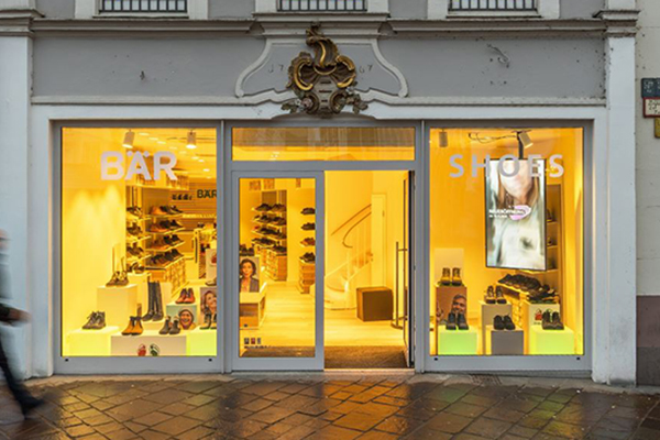Schaufenster eines stilvollen Schuhladen mit beleuchteten Regalen und vielfältigen Schuhangeboten