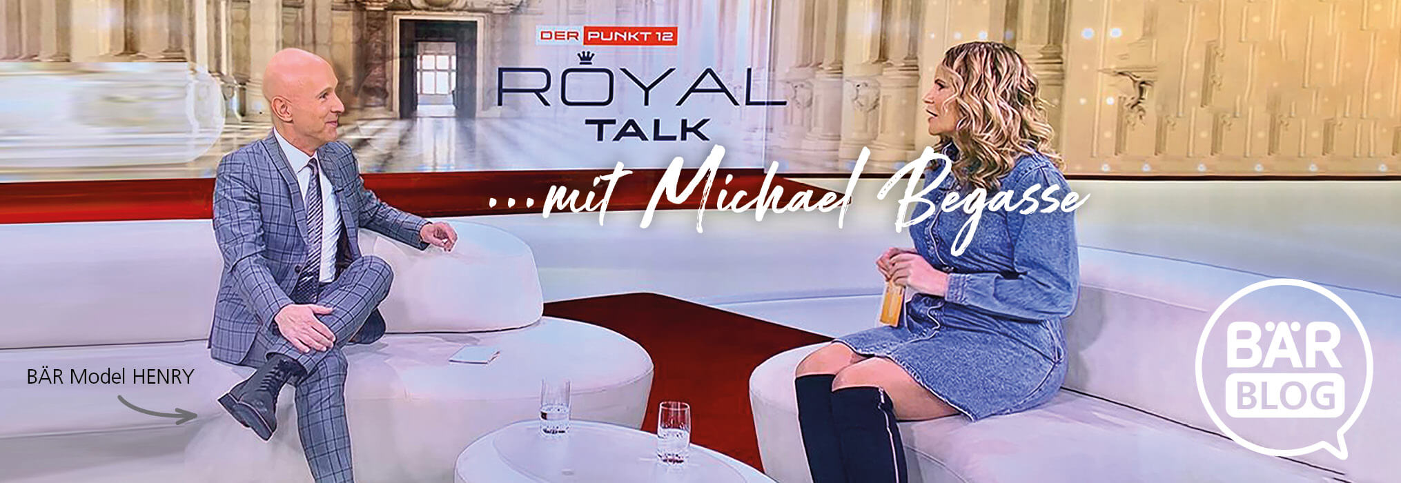 Talkshow-Szene mit Gästen auf weißen Sofas im Studio Talkshow-Szene mit Gästen, die auf weißen Sofas im Studio sitzen; Hintergrund Text 'Royal Talk mit Michael Begasse'
