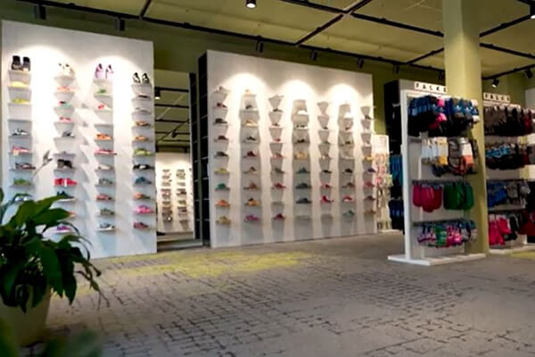 Moderne Schuhgeschäft-Innenansicht mit verschiedenen Sneaker-Modellen Innenansicht eines modernen Schuhgeschäfts mit Regalreihen voller verschiedener Sneaker-Modelle, farbenfrohe Auswahl an Wanddisplays.