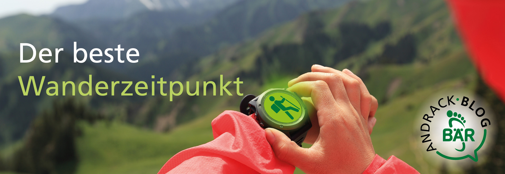 Der beste Wanderzeitpunkt mit Andrack Blog Bär Nahaufnahme einer Hand, die eine grüne Smartwatch mit Wander-Symbol hält, im Hintergrund unscharfe Berglandschaft und Andrack Blog Bär Logo